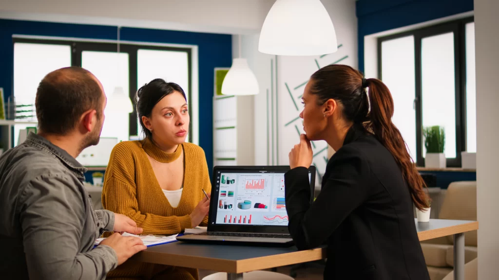 Young Workers Group Talking Looking at Laptop